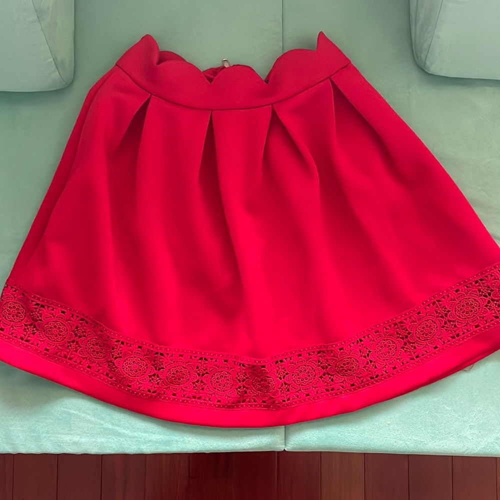Red midi skirt with scalloped waistband and lace detail on bottom.